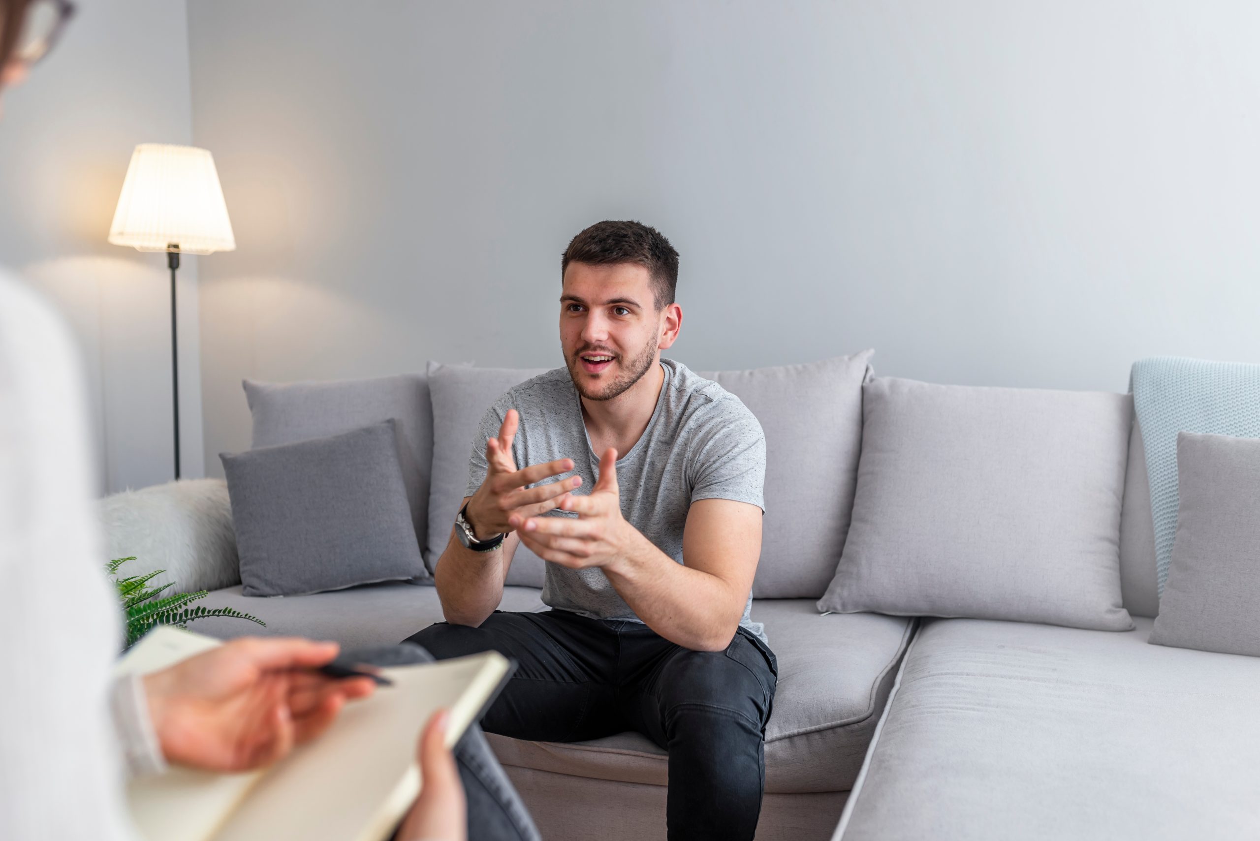 Psychologist talking with happy man in the office. Image of youn a man in a therapy session
